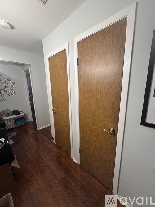 A hallway with two doors and a white wall.