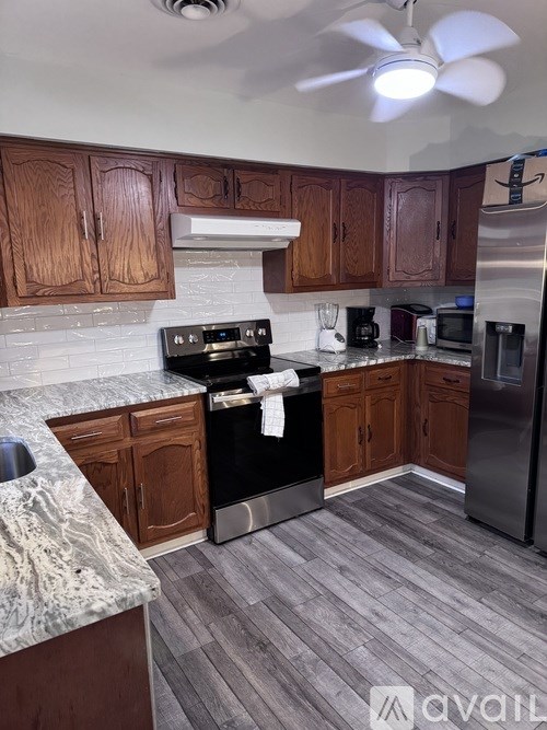 A kitchen with wooden cabinets and a marble countertop.