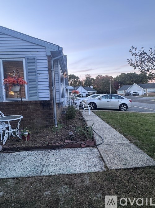 A house with a blue siding and a white car parked in front.