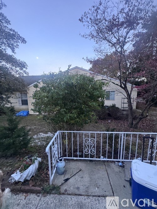 A white fence with a heart design on it is in front of a house.