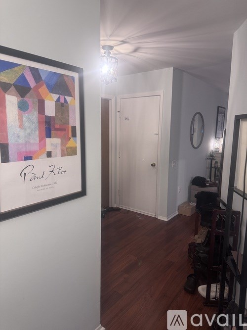 A hallway with a painting on the wall and a white door.