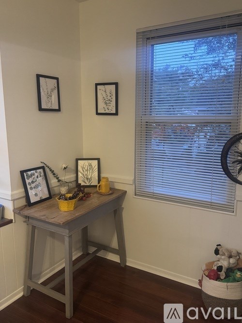 A room with a table and three pictures on the wall.