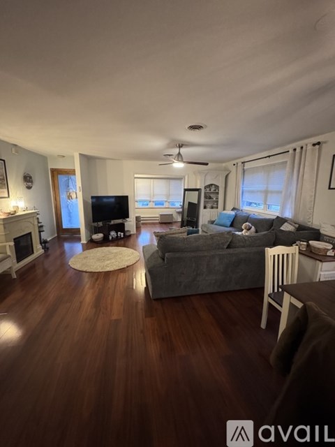 A living room with a grey couch and a television.