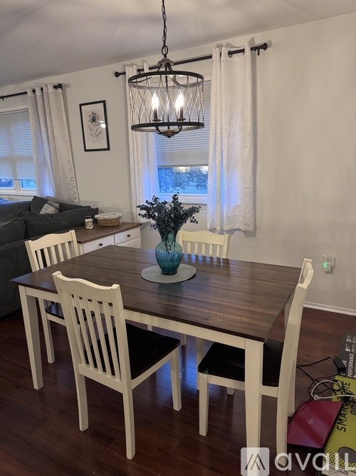 A dining room with a wooden table and chairs.