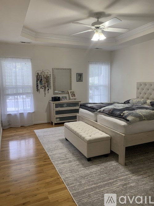 A bedroom with a large bed, a bench, and a dresser.