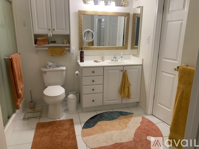 A bathroom with a toilet, sink, and mirror.