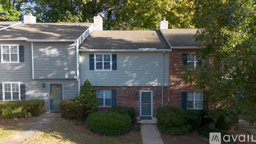 A house with a grey roof and a blue door is for sale.