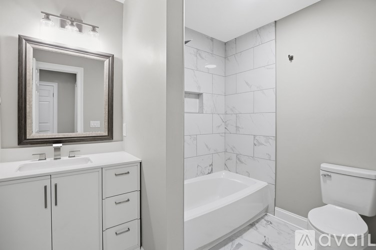 A bathroom with a white tub, sink, and toilet.