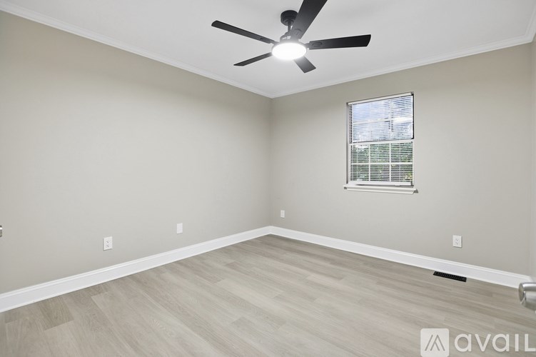 A room with a ceiling fan and a window with blinds.