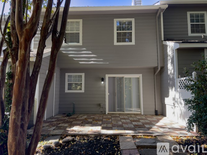 A house with a grey exterior and a stone patio.