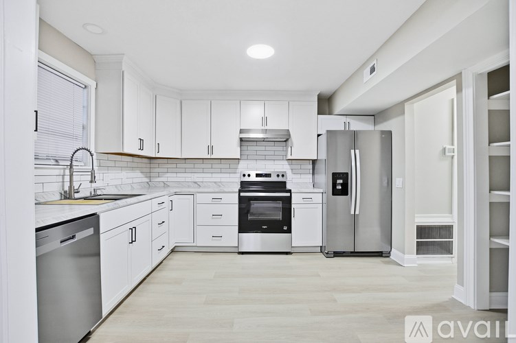 A modern kitchen with white cabinets and stainless steel appliances.