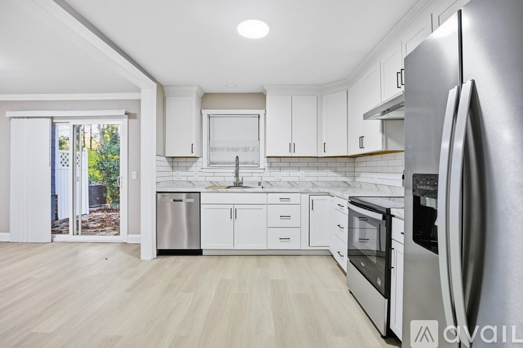 A modern kitchen with white cabinets and stainless steel appliances.