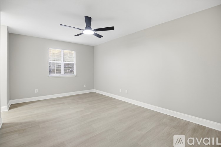 A room with a ceiling fan and a window.