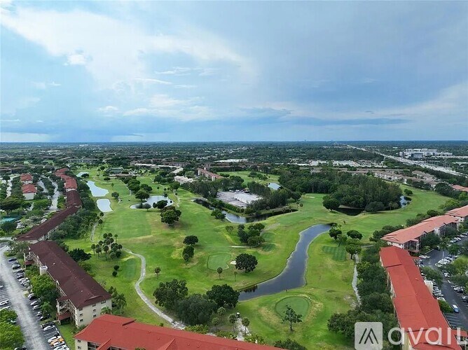 A golf course with a clubhouse and a parking lot.