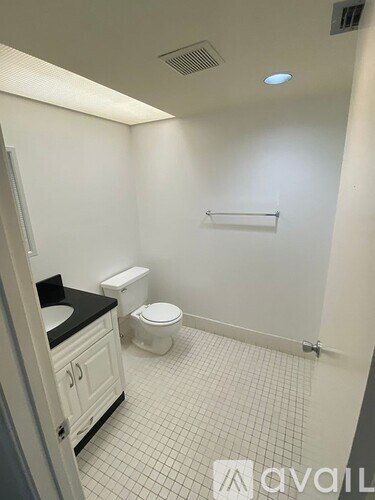 A bathroom with a toilet, sink, and a towel bar.