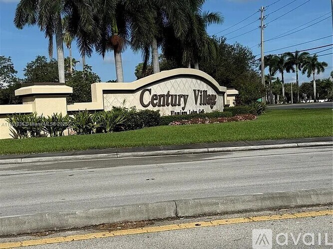 A street sign for Century Village is in front of a row of palm trees.