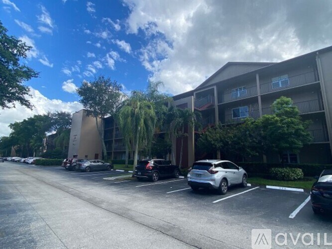 A parking lot with cars and a building in the background.