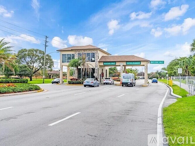 A street view with a building on the right and cars on the road.