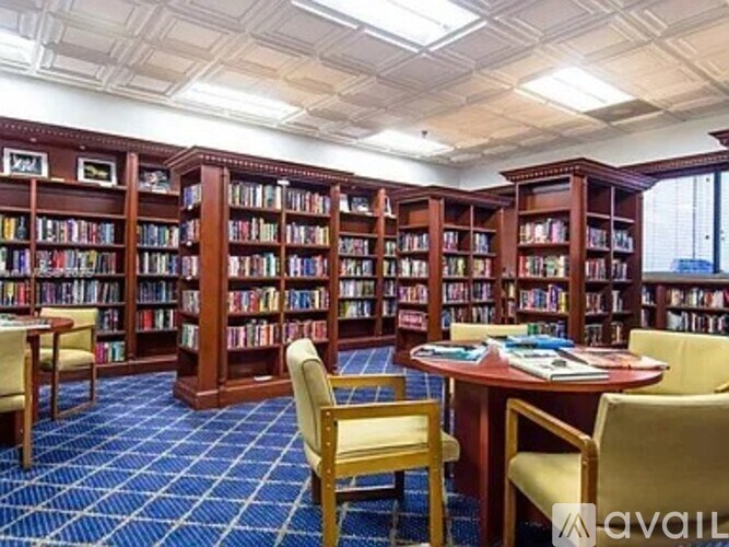 A library with bookshelves, tables, and chairs.