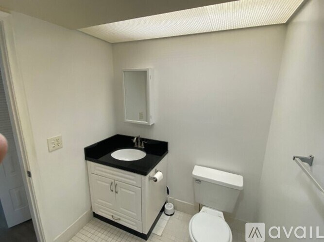 A bathroom with a sink, toilet, and a cabinet.