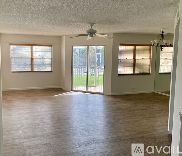 A spacious room with a sliding glass door leading to a balcony.