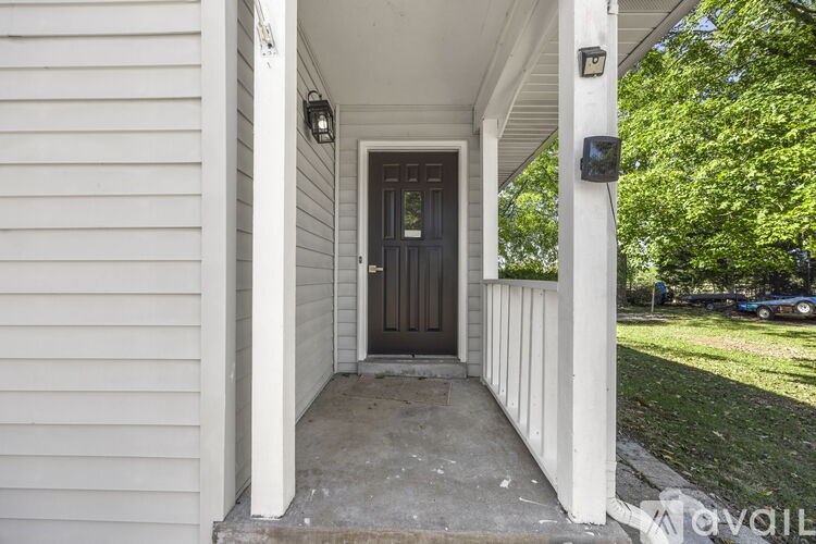 A front porch with a dark brown door and white columns.