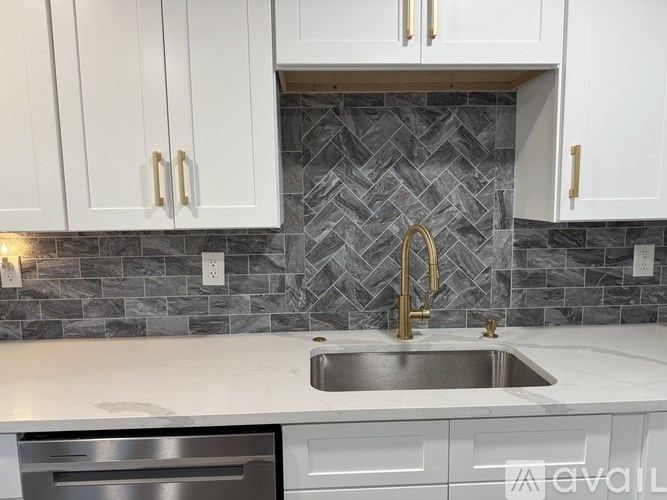 A kitchen with a sink and a backsplash.
