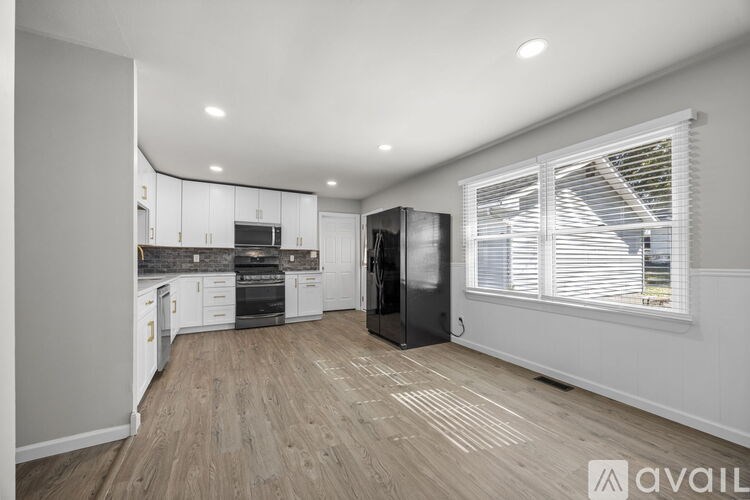 A kitchen with wooden floors and white walls.