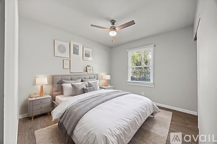 A well-lit bedroom with a large bed and a ceiling fan.