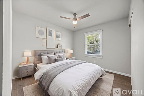A well-lit bedroom with a large bed and a ceiling fan.