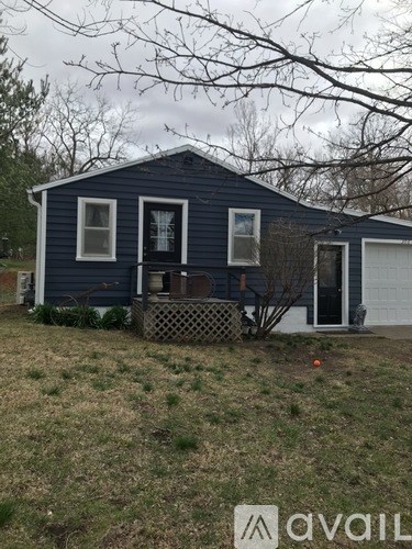 A blue house with a white garage door and a brown fence.