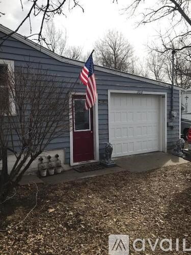 A blue house with a red door and an American flag on the window.
