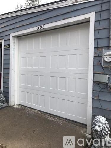 A white garage door with the number 306 on the wall above it.