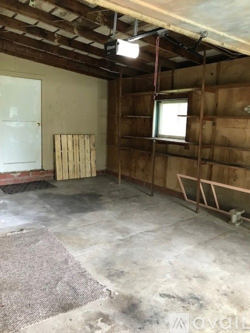 A room under construction with wooden walls and a window.