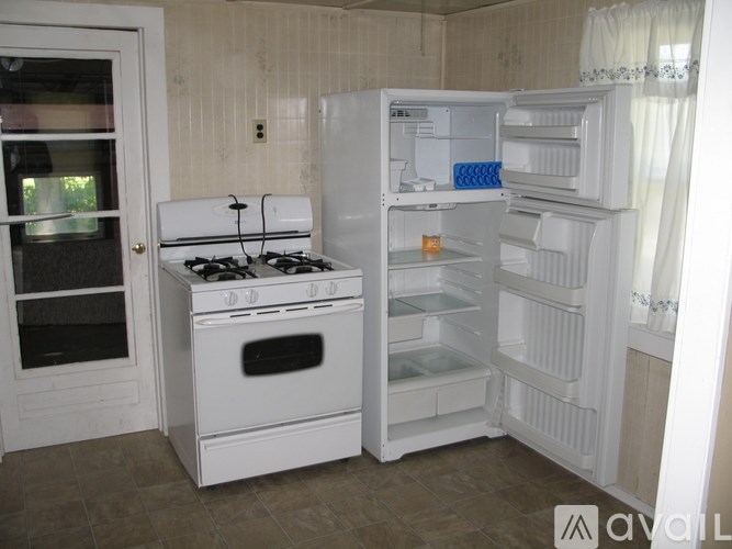 A white kitchen with a stove, oven, and refrigerator.