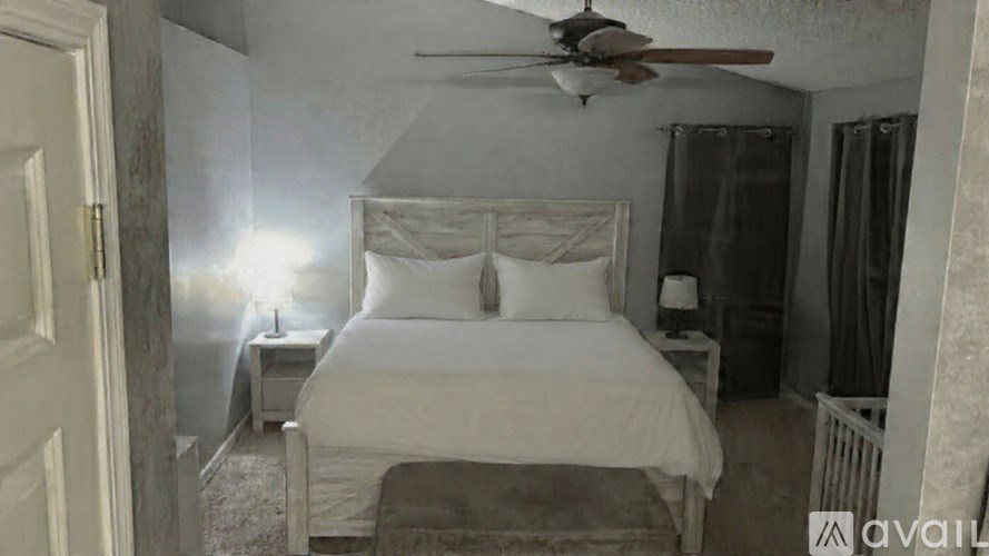 A bedroom with a bed, nightstand, and a ceiling fan.