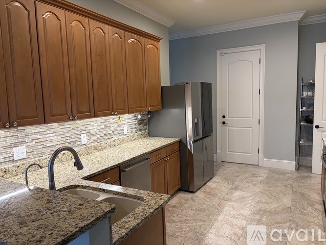 A kitchen with brown cabinets and a granite countertop.
