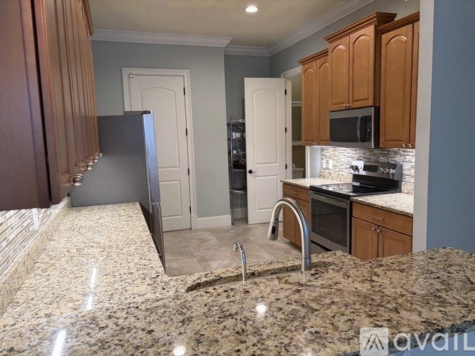 A kitchen with granite countertops and wooden cabinets.