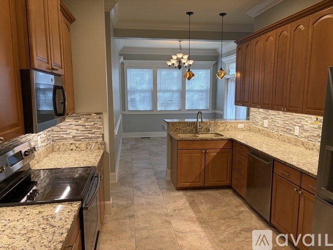 A kitchen with granite countertops and wooden cabinets.