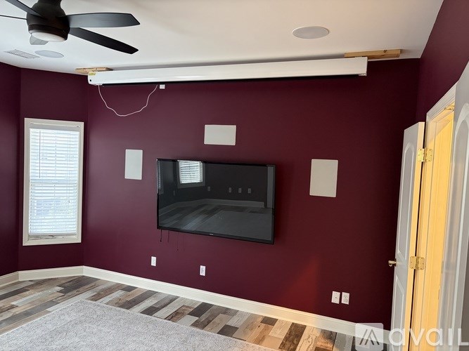 A living room with a flat screen TV mounted on the wall.