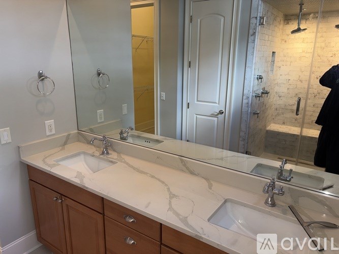 A bathroom with a marble countertop and double sinks.