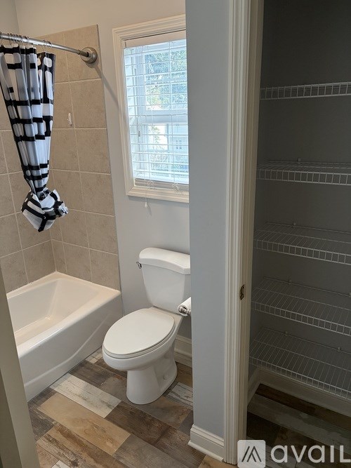 A white toilet in a bathroom with a striped shower curtain.