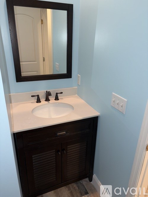A bathroom with a sink and a mirror.