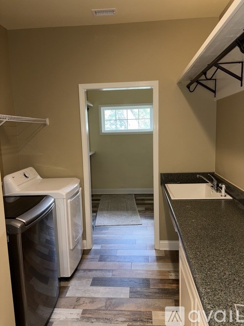 A bathroom with a toilet, sink, and a doorway leading to a shower.