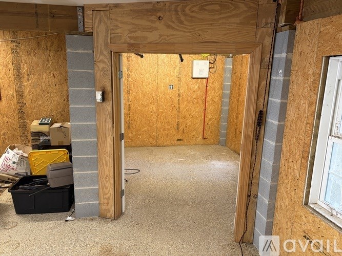 A room under construction with a doorway open and a toolbox on the floor.