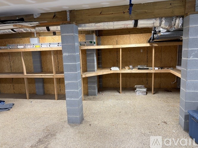 A room under construction with wooden beams and concrete pillars.