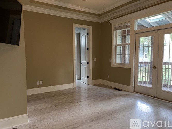 A spacious room with a doorway leading to another room.