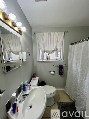 A bathroom with a sink, mirror, toilet, and shower.