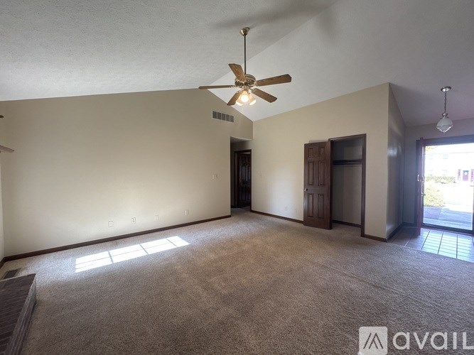 A room with a ceiling fan and carpeted floor.