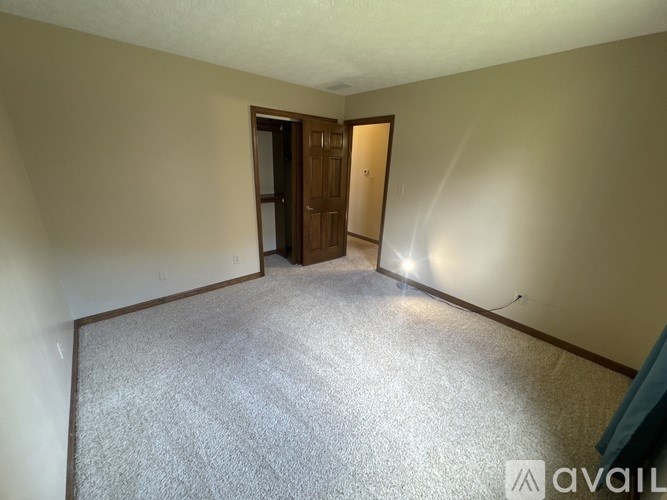A room with a carpeted floor and a doorway leading to another room.
